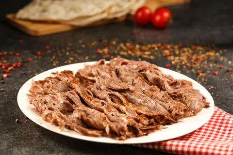 Portion Doner kebab meat served in plate with Pita Bread, knife, fork and t.. Foto stock