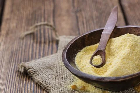 Portion of fresh Cornmeal (close-up shot) on rustic wooden background Stock Photos