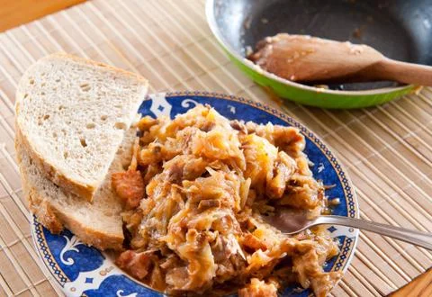 Portion of hot Polish bigos with bread on plate Stock Photos