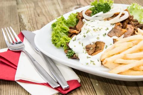 Portion of kebab meat with chips Stock Photos