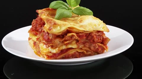 A portion of lasagne with basil on a plate Stock Footage 8571510