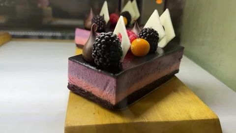 A portion of layered cream with a chocolate layer of cake with blackberries, sea Stock Footage 299619006
