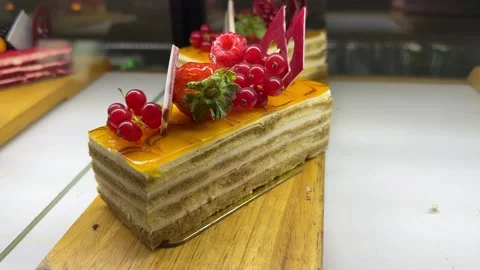 A portion of layered cream yellow cake with red raspberries, red currants on a Stock Footage 300053097