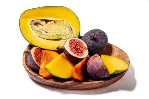 Portion of mango, persimmon and figs on a wood platter  isolated on white Stock Photos