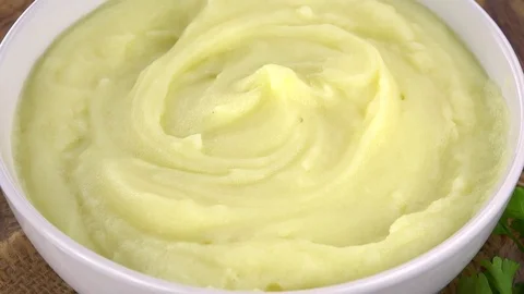 Portion of Mashed Potatoes rotating on a wooden plate (not loopale; 4K) Stock Footage