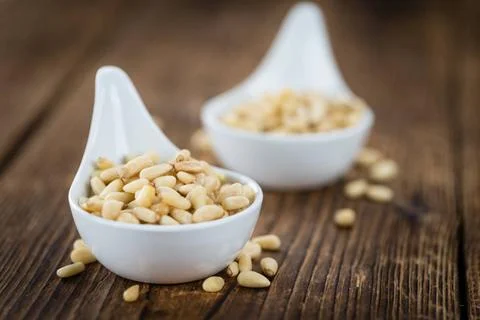  Portion of Pine Nuts on wooden background (selective focus) Pine Nuts on ... Foto stock