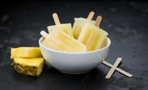Portion of Pineapple Popsicles on a slate slab (selective focus; close-up sho Stock Photos