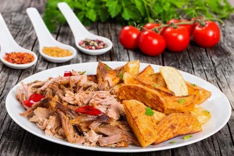 Portion of pulled slow-cooked delicious meat with fried potato Stock Photos