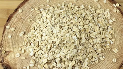 Portion of raw rolled oats rotating in wooden rustic table Stock Footage 275511624