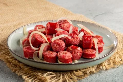 Portion of sausage with onion. Stock Photos