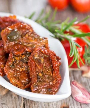 Portion of sun dried Tomatoes with fresh herbs 写真素材