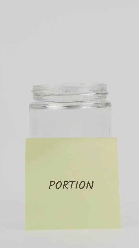 Portion text or word on yellow sticky note attached to glass jar with hand Stock Footage 311769396