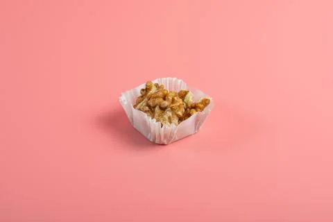 Portion of walnuts in a paper muffin cup on a pink background Stock-Fotos