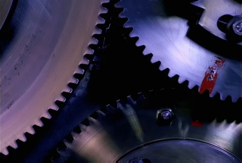 Portions of two interlocking gears and an independent gear turning in close-up Stock Footage 86885859