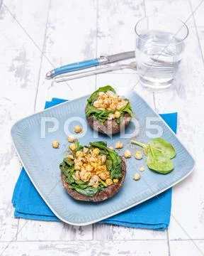 Portobello mushrooms filled with spinach and chickpeas Stock Photos