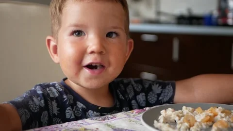 Portrait of 2 years old boy laughs and smiles, eats with great appetite. Stock Footage 153397270