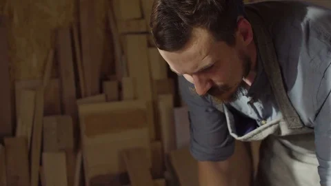 Portrait of 20s bearded woodworker using brashing machine with wooden plank in Stock Footage 76095098
