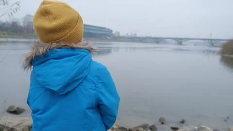 Portrait of a 5-year-old boy on a cold day near the river 스톡 동영상 165453046