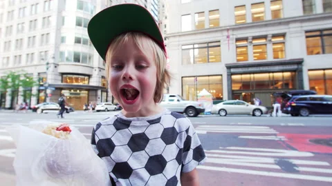 Portrait of a 5 years old boy eating a hotdog at the street in New York. Stock Footage 208692566
