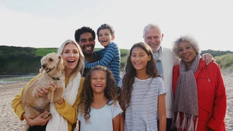 Portrait Of Active Multi-Generation Family With Pet Dog On Winter Beach Vacation Stock Footage 124573107