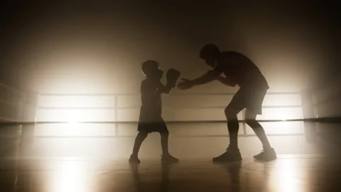 Portrait of active, skilled kid wearing boxing gloves and training in a sparring 스톡 동영상 233740577