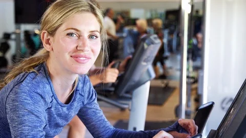 Portrait Of Active Woman Resting After Exercising On Cycling Machines In Gym Stock Footage