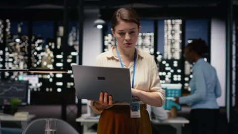 Portrait of administrator using laptop in office to evaluate business efficiency Stock Footage 334044513