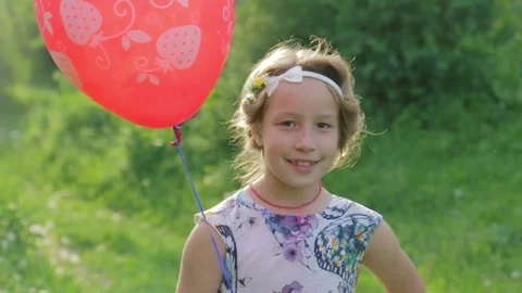 Portrait adorable girl with a balloon looking at the camera Stock Footage 85001453