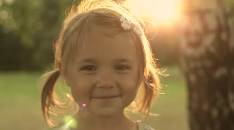 Portrait Adorable Little Girl Smiles outdoor at sunset Stock Footage