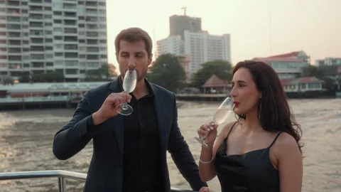 Portrait of affectionate Hispanic couple clinks champagne glasses sailing yacht Stock Footage 309047100