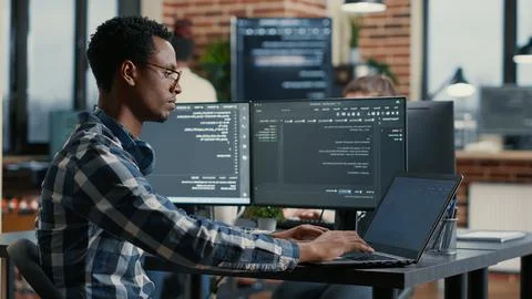 Portrait of african american developer using laptop to write code sitting at 스톡 사진