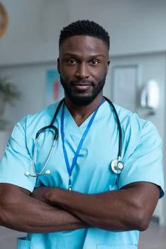 Portrait of african american male doctor with stethoscope wearing scrubs in Stock Photos