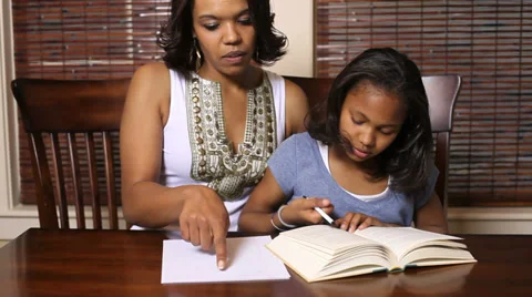 Portrait of African American mother helping her daughter with homework Stock Footage