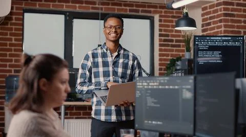 Portrait of african american software developer holding laptop looking up and 写真素材