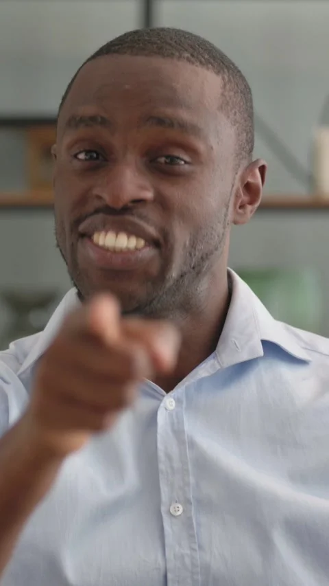 Portrait of African Man Pointing at Camera Sitting on Sofa at Home Stock Footage 301856673