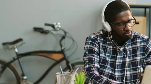 Portrait of african young business man in glasess listening music in headphone Stock Footage