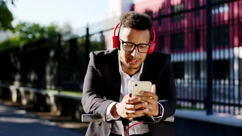 Portrait of a Afro American guy student listening music wearing big red Video stock 138159383
