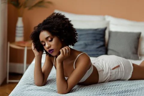 Portrait of Afro-American pretty young woman in cozy apartment, beutiful curly Stock Photos