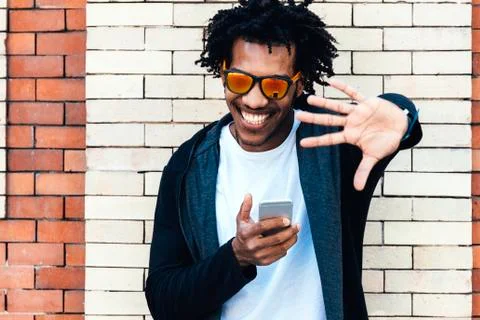 Portrait of afro handsome man using his mobile. Stock Photos