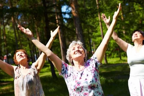 Portrait of aged women with their arms raised in praise Stock Photos