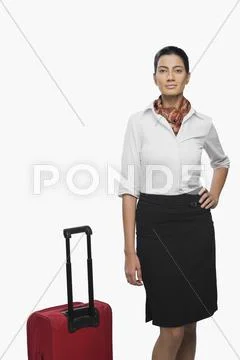 Portrait of an air hostess with her luggage Stock Photos