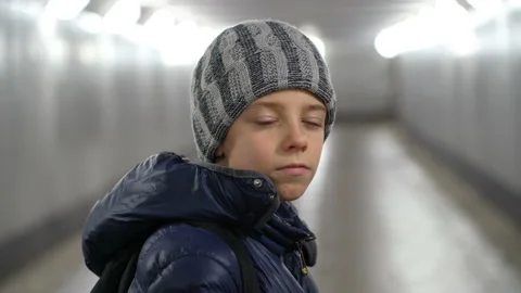 Portrait of alone confident boy in hat and jacket in underground covered walkway Stock Footage 167823913