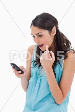Portrait of an amazed woman reading a text message Stock Photos