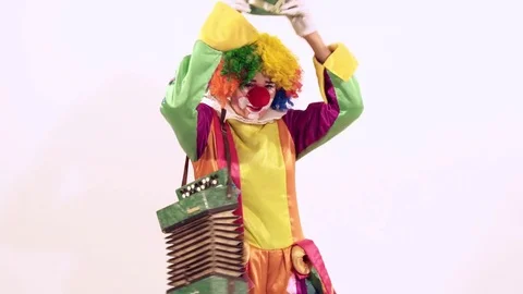 Portrait of amusing circus clown playing the harmonica enthusiastically Видео 70508572