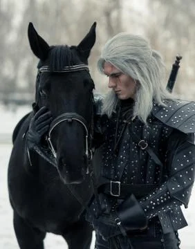 Portrait of ancient warrior witcher next to a horse. Stock Photos