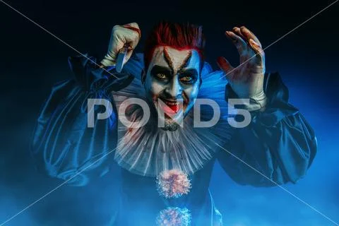 A portrait of an angry crazy clown from a horror film with a knife. Halloween Stock-Fotos
