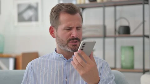 Portrait of Angry Middle Aged Man Talking on Phone at Home Video stock 287897591