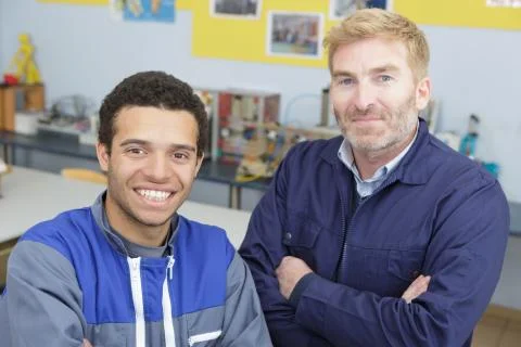Portrait of apprentice and engineer in workshop Stock Photos