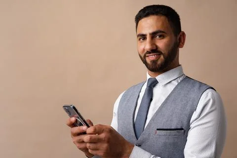 Portrait of arab man using his smartphone in studio Stock Photos