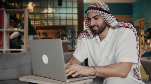 Portrait arab man at work at a laptop use smile at home dubai successful hijab Stock Footage 107151287